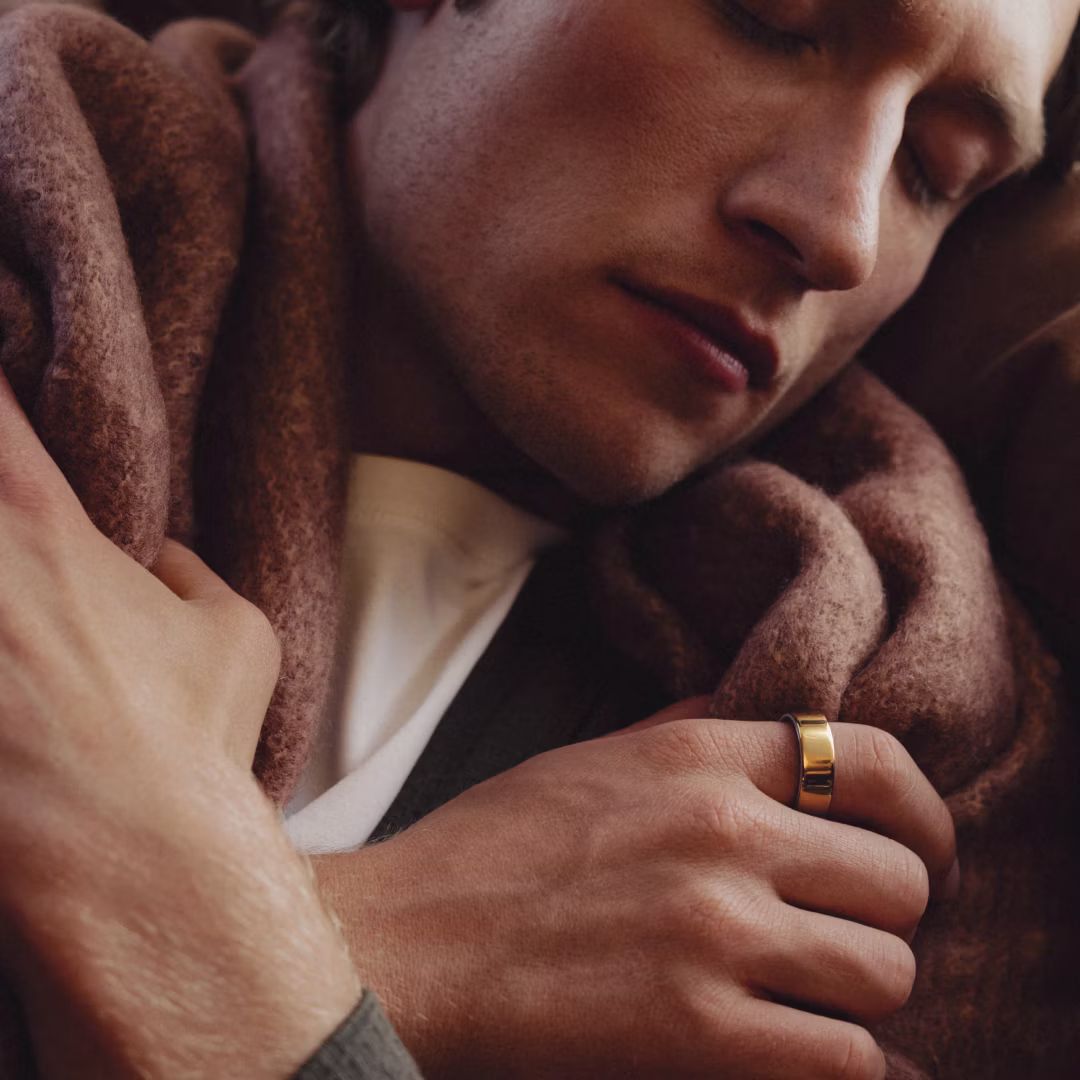 Homme en train de dormir avec une couverture, la KEORA Ring 4 gold au doigt