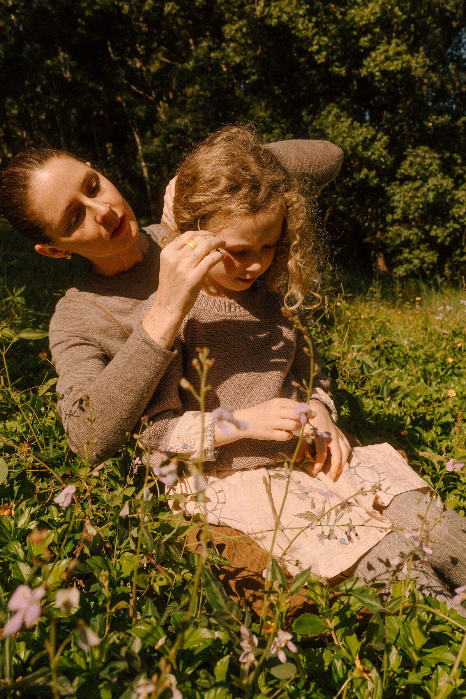Une mère, la KEORA Ring au doigt, coiffe les cheveux de sa fille.