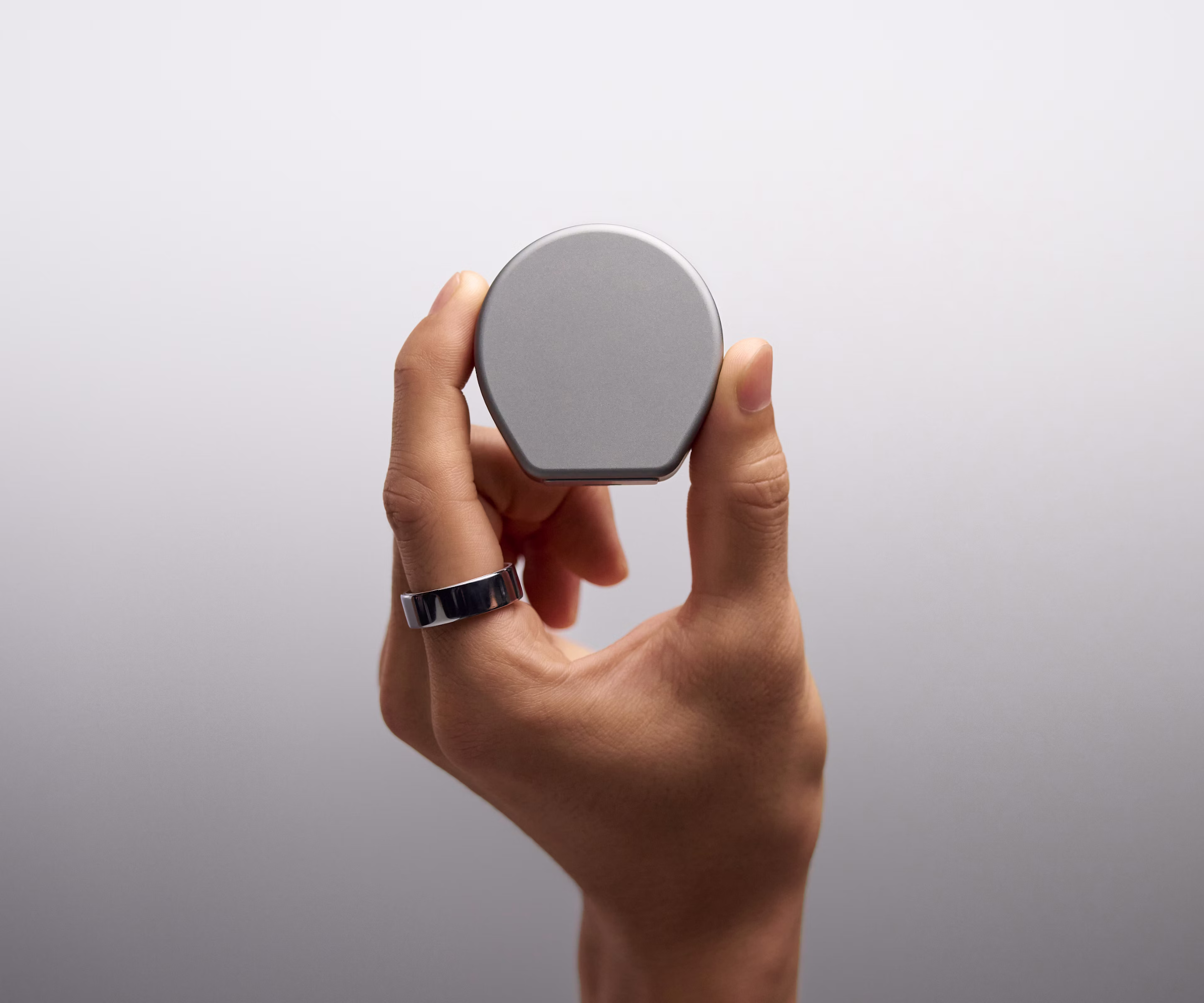 Gros plan sur une main tenant le boîtier de charge KEORA Ring 4 Charging Case avec le couvercle fermé.