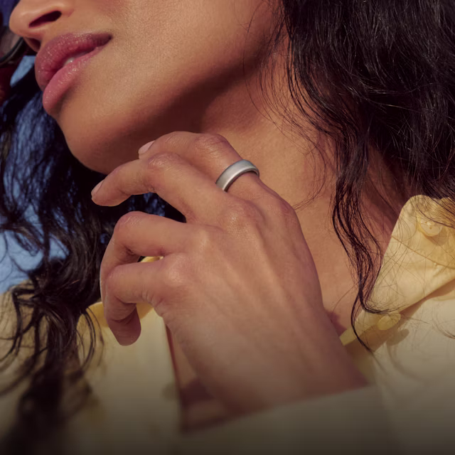 Gros plan sur une personne la main levée devant sa poitrine, la KEORA Ring 6 Brushed Silver au doigt