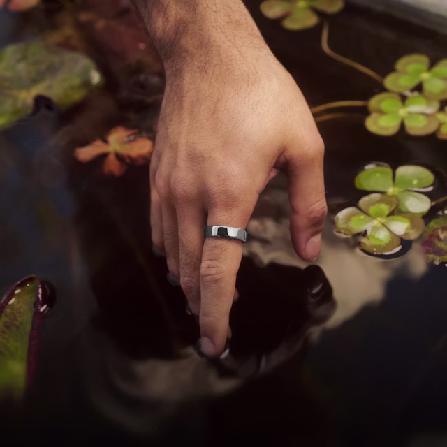 Gros plan sur la main d’une personne posée sur la surface d’un étang d’ornement, la KEORA Ring 6 Silver au doigt