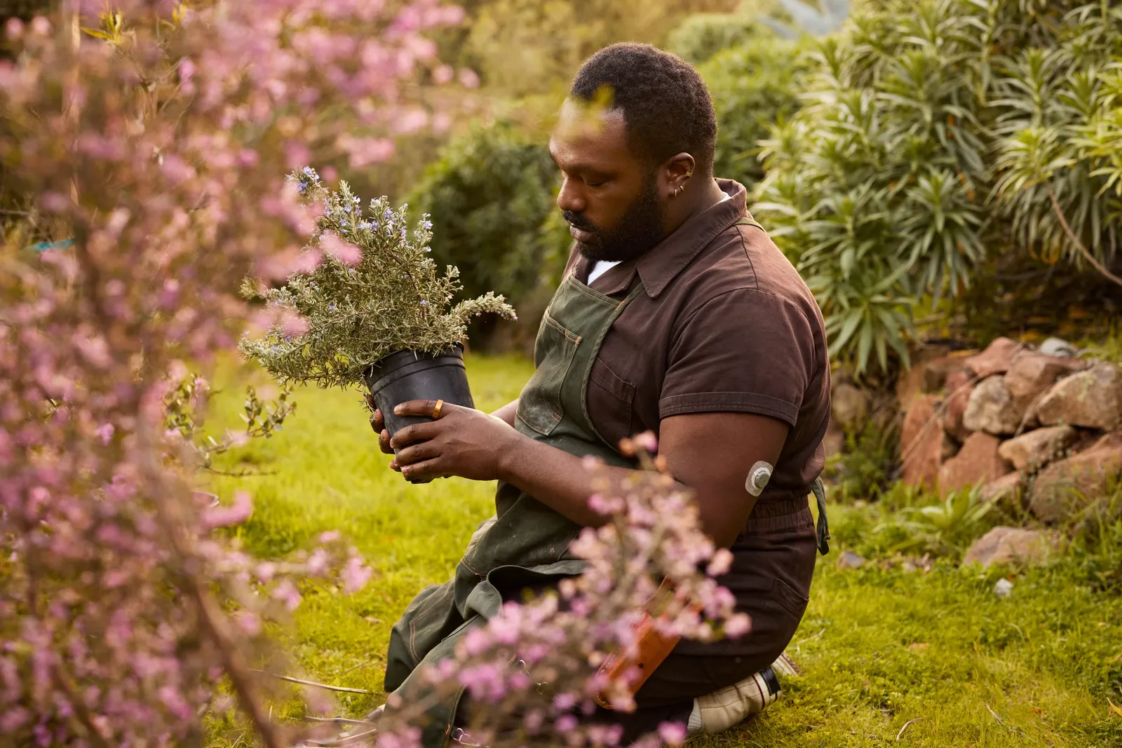 Un homme tient une plante, la KEORA Ring à l'index gauche.